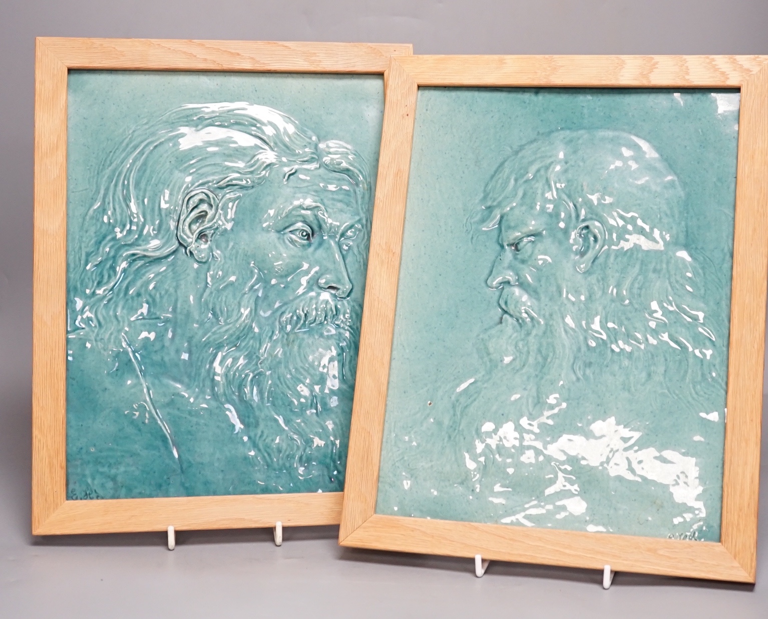 A pair of Burmantofts relief-moulded turquoise glazed portrait plaques, late 19th century, modern oak frames. 30x23cm